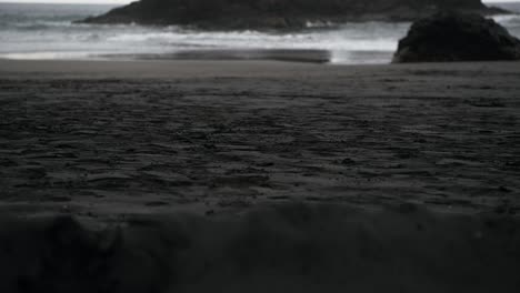 A-group-of-people-walking-on-a-black-sand-beach-in-Tenerife