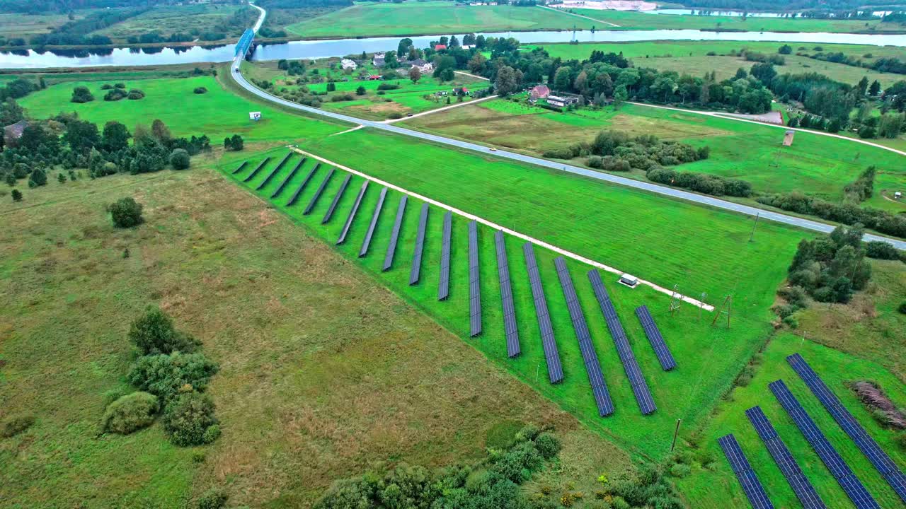 Solar panels in a green field near a Latvian river landscape