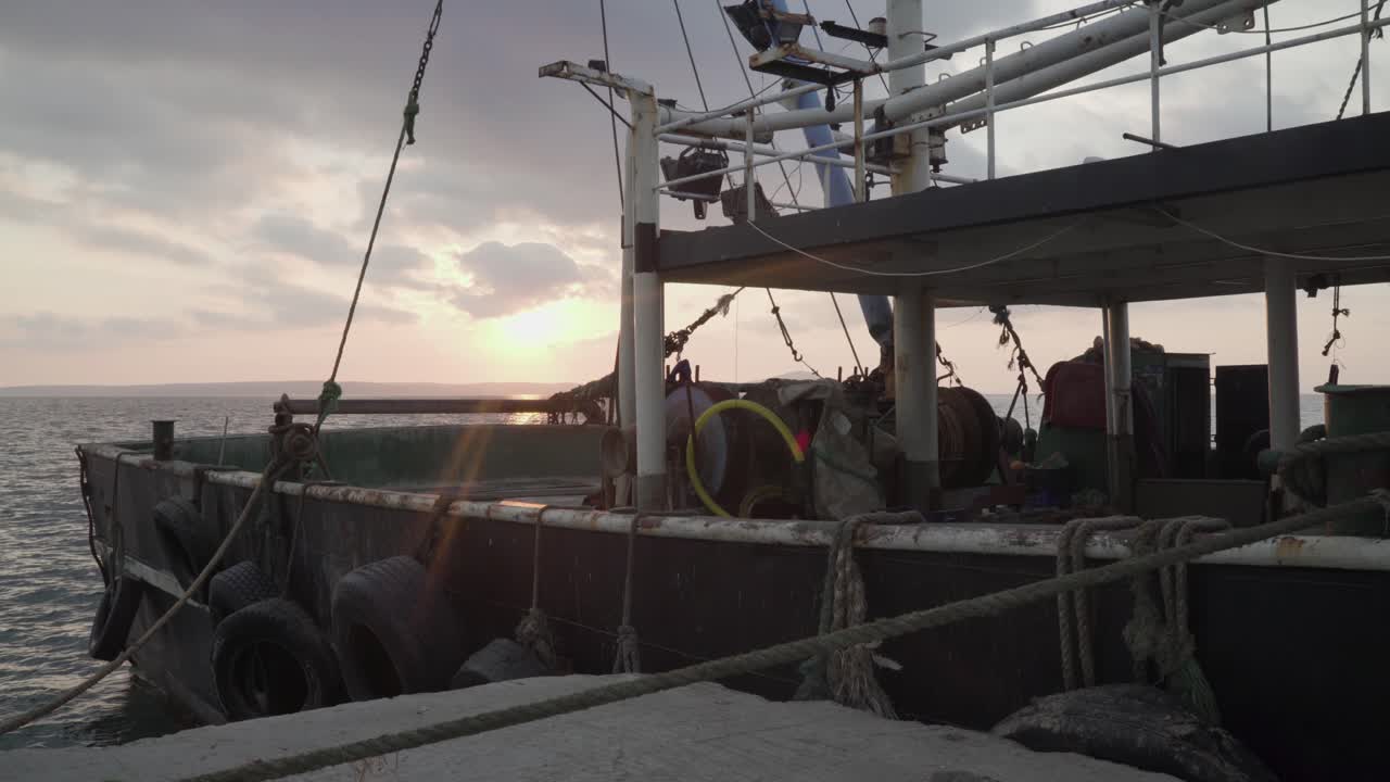 puesta de sol en el muelle cerca de un viejo barco pesquero oxidado