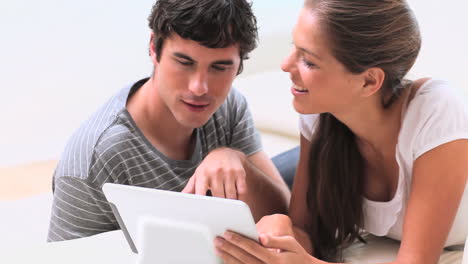 una pareja sonriente usando una tableta