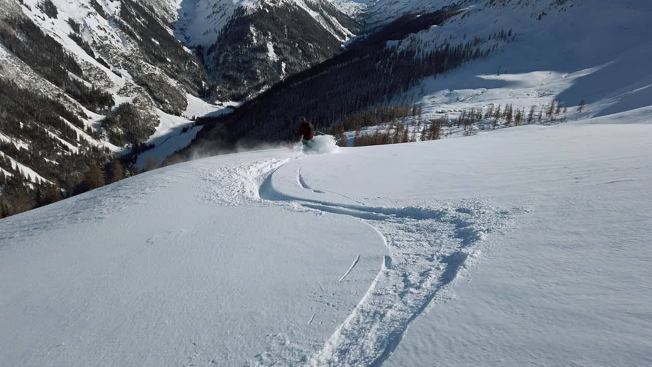 Following a lone skier breaking new powder in the Montafon range of the Austrian Alps, slow motion