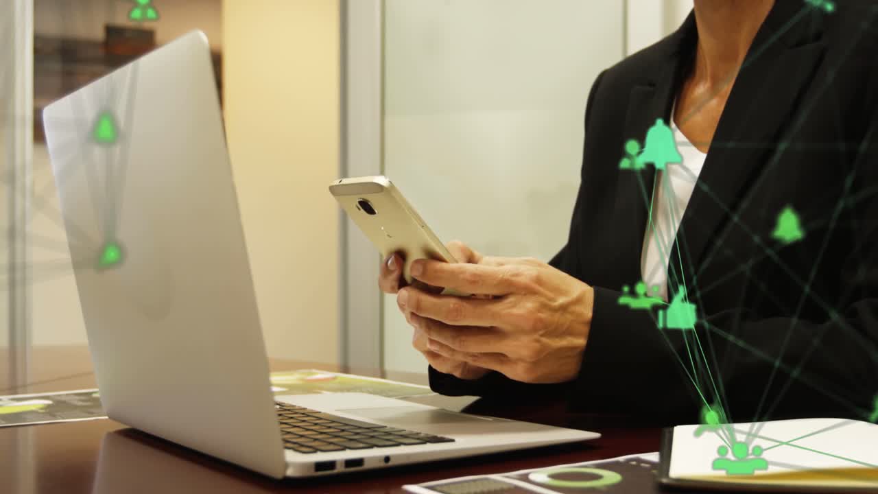 globo de iconos digitales girando contra la sección media de la mujer de negocios que usa un teléfono inteligente en la oficina