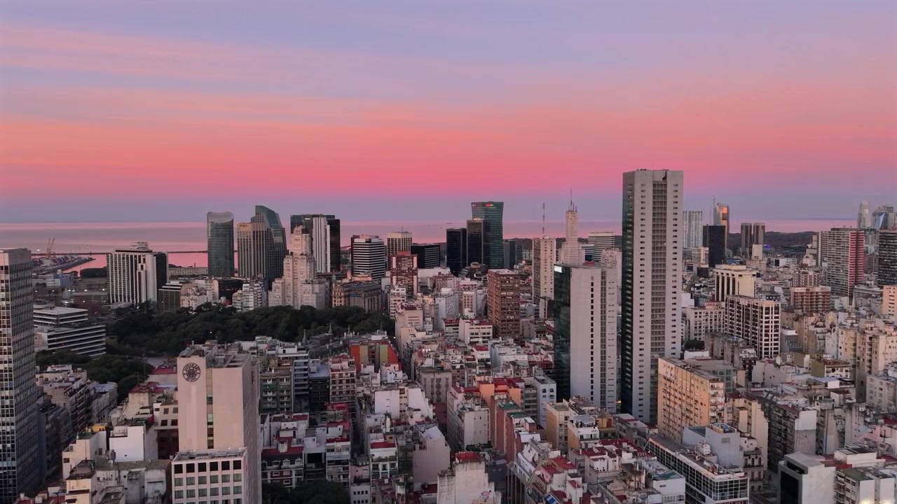 Panoramica aerea con drone dello skyline della città di Buenos Aires al tramonto rosa con lo sfondo di Puerto Madero.