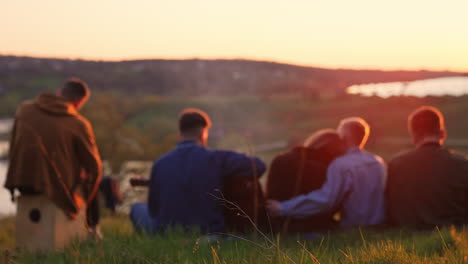 friends playing music at sunset