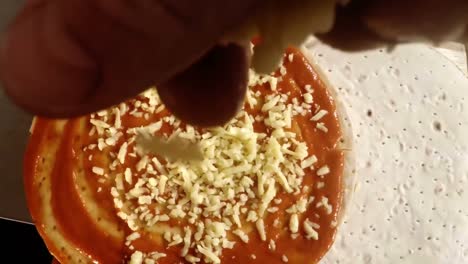 hand of chef pouring grated cheese