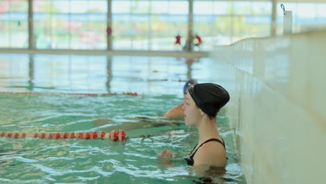 woman in an indoor pool: swimming and resting