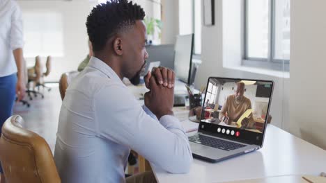 African-american-man-using-laptop-for-video-call,-with-business-colleague-on-screen