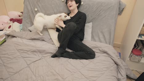 a girl at home with her dog, a cute lively jack russell terrier that tries to play with her leg