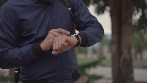 man checking smartwatch outdoors