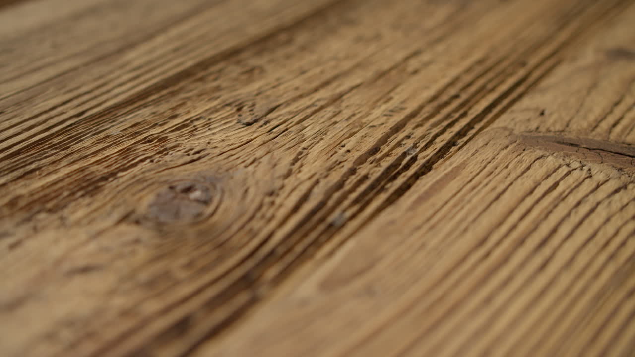 High quality video showing close up wooden surface with rich grain warm light and subtle texture captured in slow motion for a natural detailed and calm atmosphere