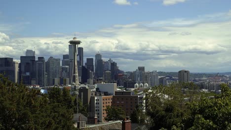 beautiful tilting up shot revealing the stunning city of seattle from kerry park with the famous space needle, skyscrapers, and residential homes surrounded by trees on a summer day in washington