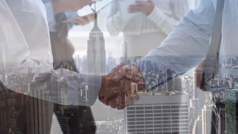 digital composition of mid section of two businessmen shaking hands against aerial view of cityscape