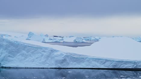 gran paisaje de icebergs de la antártida puesta de sol, grandes icibergs azules masivos con formas increíbles y dramáticas couds y cielo en el amanecer paisaje marítimo de invierno en la península antártica en escena helada