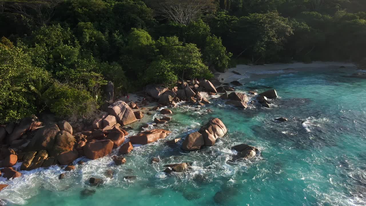 Pemandangan di Seychelles direkam dengan drone dari atas, menunjukkan laut, bebatuan, pohon palem.