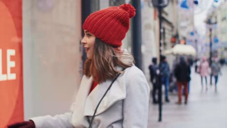 mujer joven mirando la ventana de la tienda con ropa