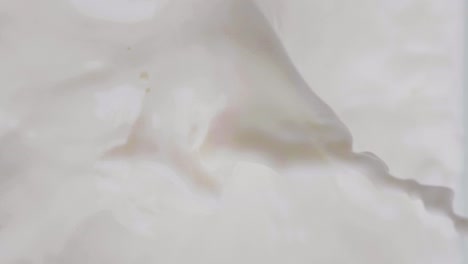 static close-up of lactose-free vegan oat milk while chocolate chunks fly in