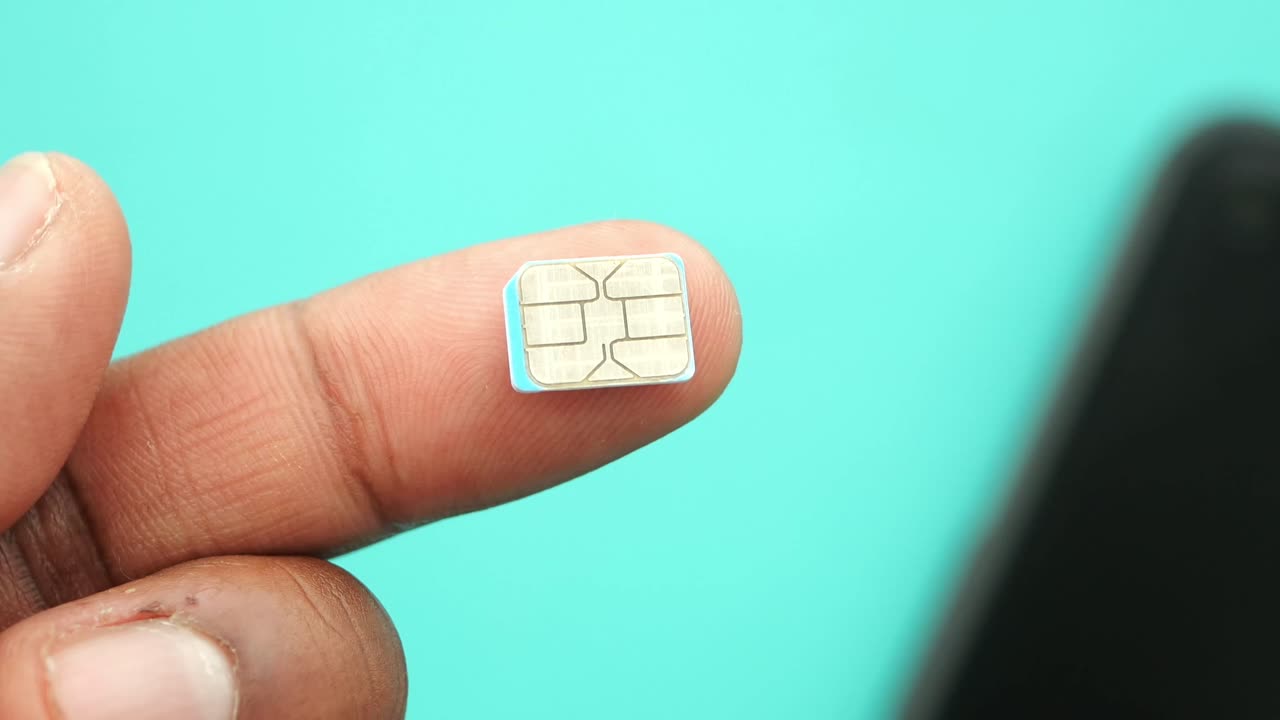A hand holding a tiny SIM card