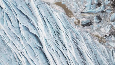 la tierra cubierta de nieve y hielo presenta un paisaje sereno y etéreo, vista aérea de arriba hacia abajo del glaciar