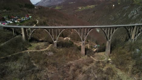 drone footage flying along the durdevica tara bridge in montenegro as cars drive over it