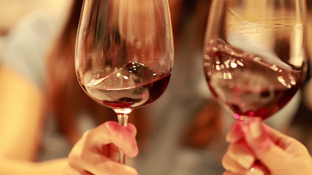 A person swirls red wine in a glass, highlighting aeration in a warm, intimate dining environment
