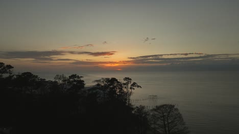 Aerial-view-of-sunset-while-drone-descends-in-Mobile-Bay,-Alabama