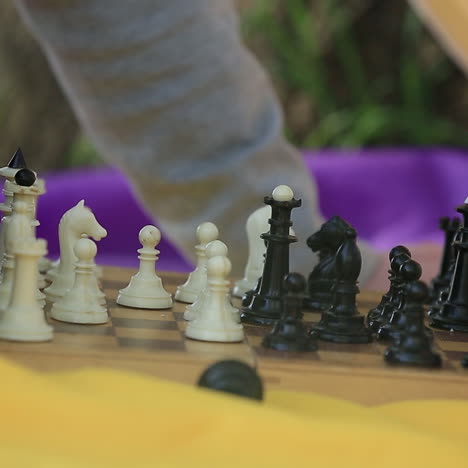 man and woman playing chess. chess pieces on the board.