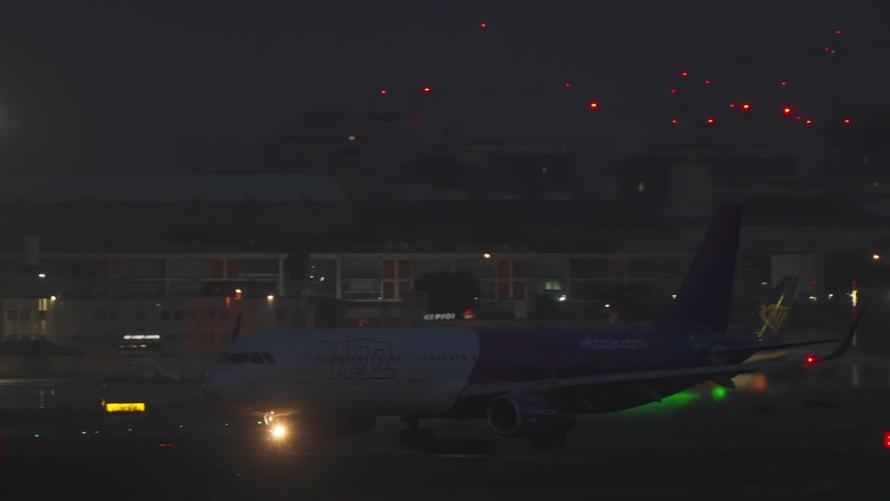 夜の空港滑走路をタキシングする民間航空機
