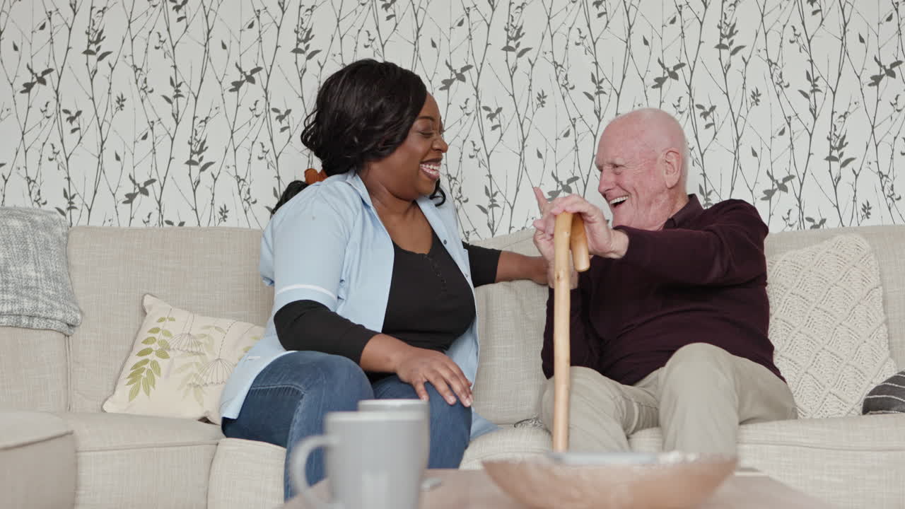 Caregiver laughing with elderly man