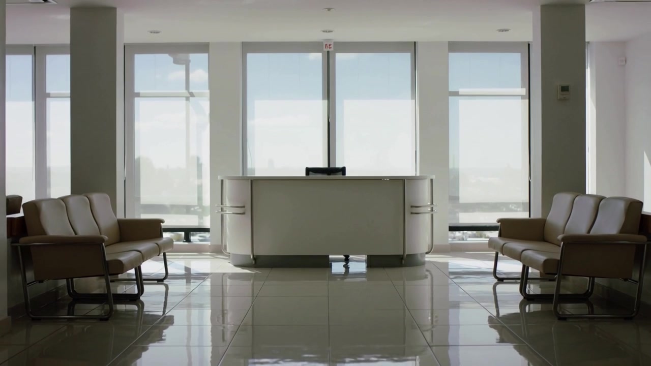 Kameravogn starter og afslører central reception på øverste etage, viser skærmrefleksioner