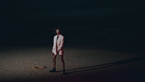glamour model stepping shore at night. stylish   turning camera