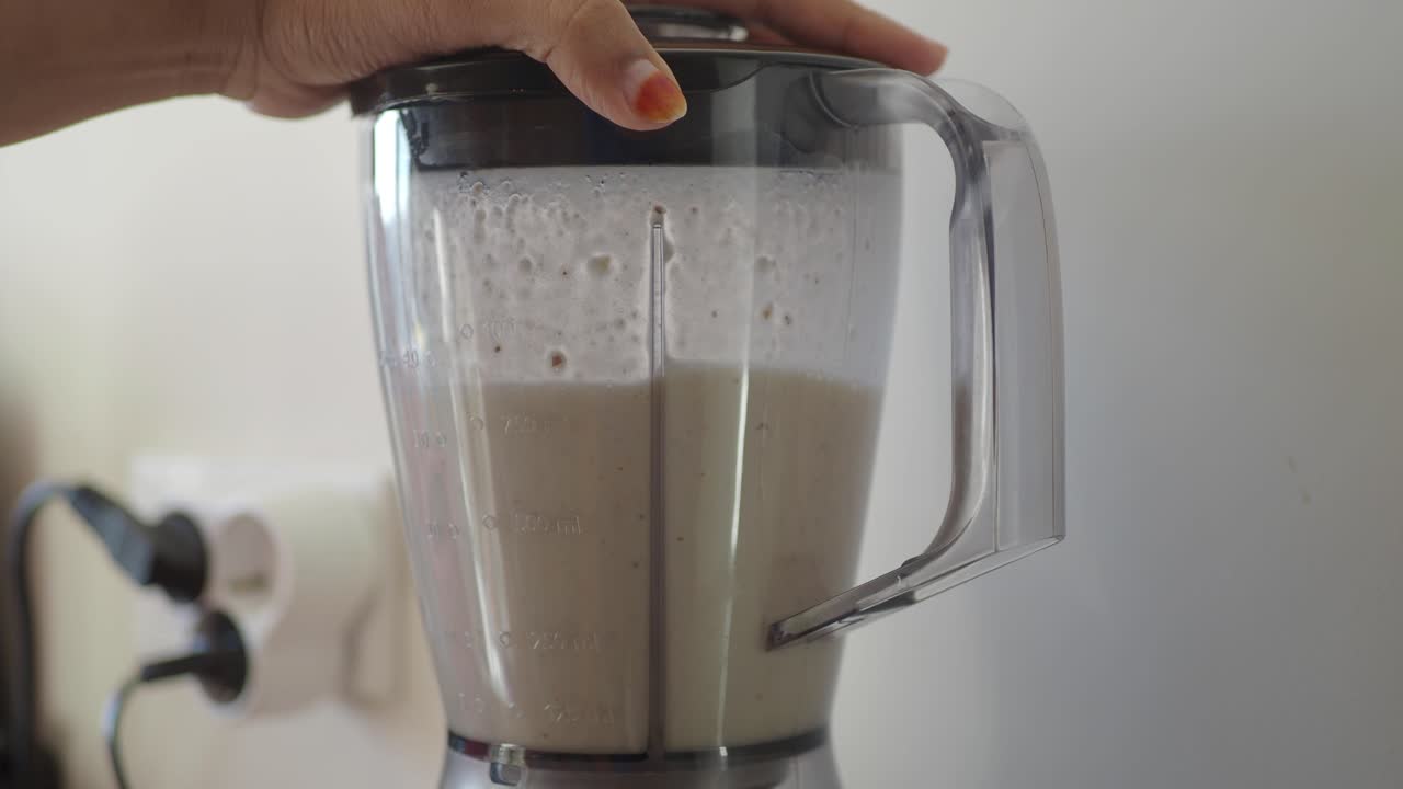 mujer haciendo un batido en una licuadora