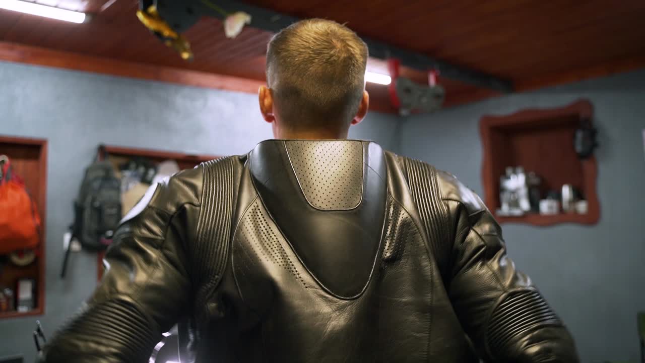 Man in Motorcycle Leather Jacket in a Garage