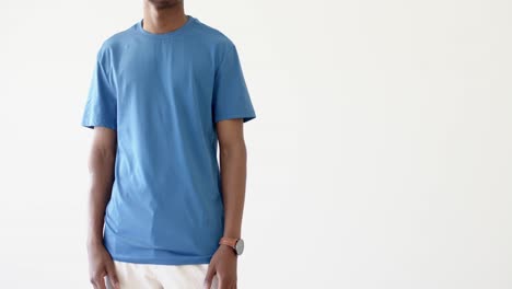 midsection of african american man wearing blue t-shirt with copy space on white background