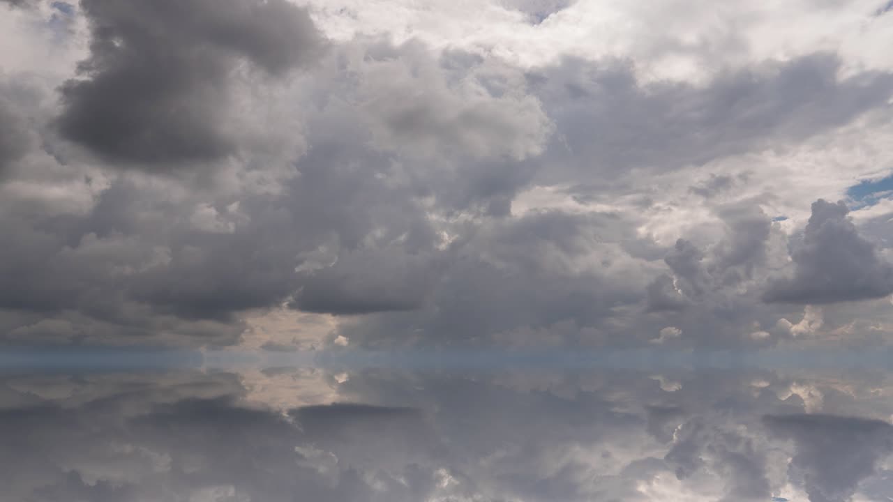 futuristic background consisting of Time lapse clip of white fluffy clouds over blue sky and their reflection, video loop