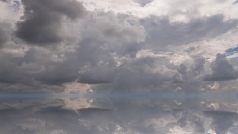 futuristic background consisting of time lapse clip of white fluffy clouds over blue sky and their reflection, video loop