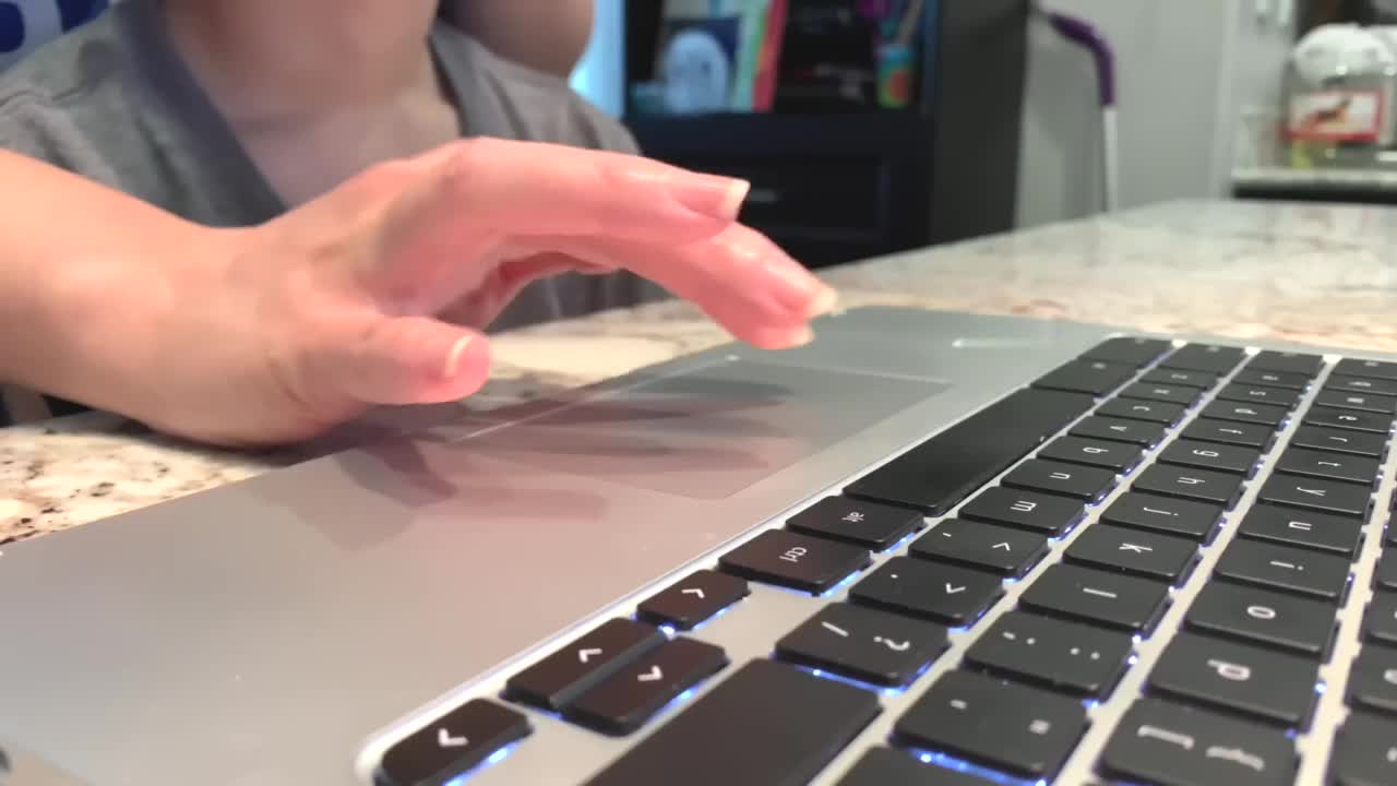 Adult helping child with online distance learning on a chrome book.  Home schooling. Close-up. 4K stock footage