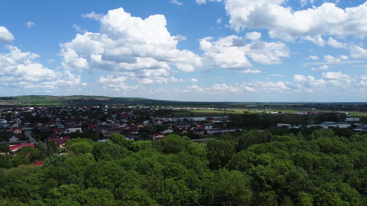 Luftfoto af en lille landsby bag skoven