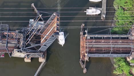 boat passing beneath open railroad drawbridge on cheesequake creek in morgan, nj