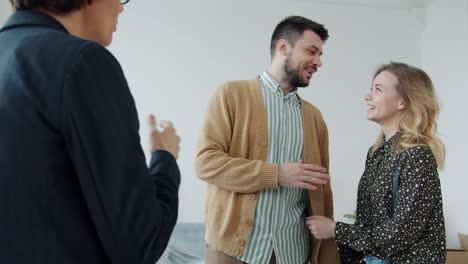 happy couple viewing new house with realtor