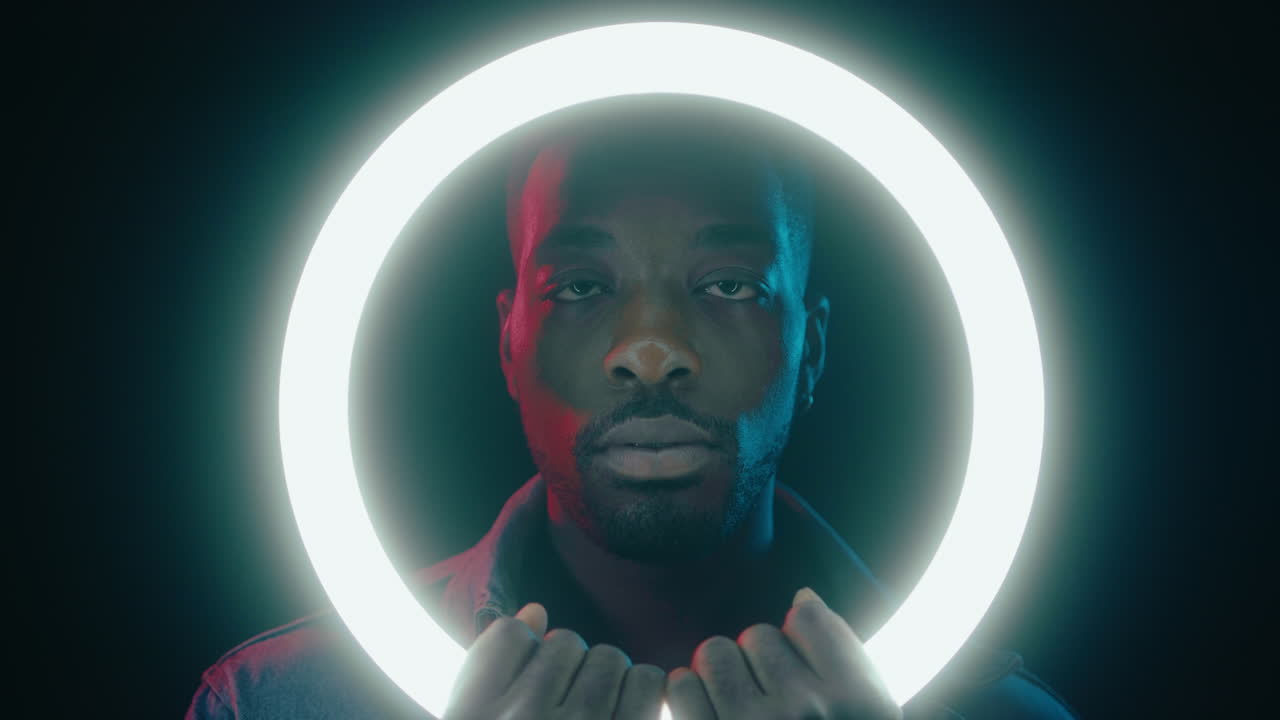 African American Man Posing with Ring Light in Dark Studio