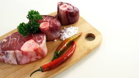 carne cruda e ingredientes en tablero de madera
