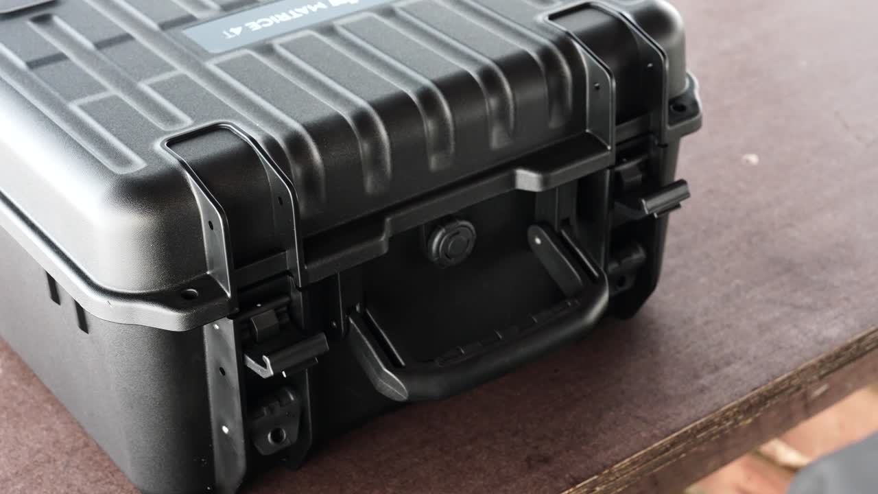 Gloved hands opening clips on protective drone case, Czechia