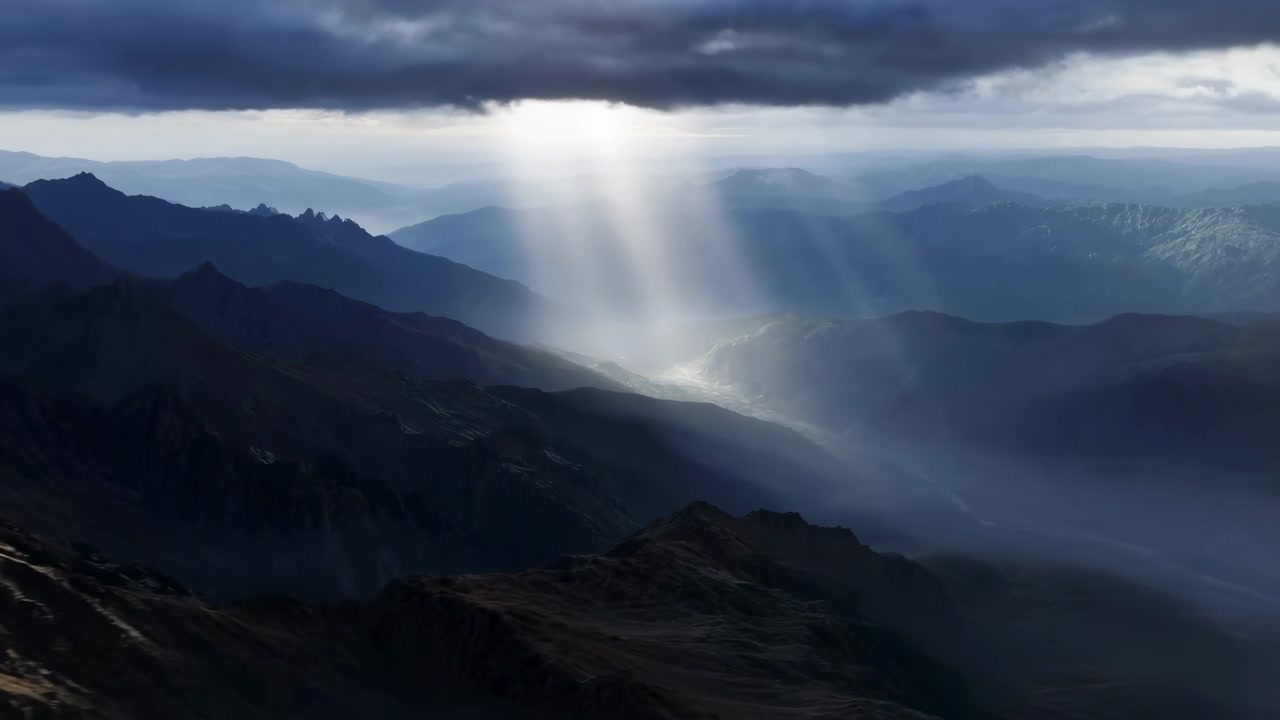 Veduta aerea elevata di una catena alpina a strati sotto una densa copertura di nubi stratocumulo, dove fasci concentrati di luce pallida si fanno strada e illuminano la valle, le creste e il lago calmo sottostante.
