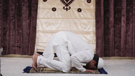 indian muslim man praying to allah at home