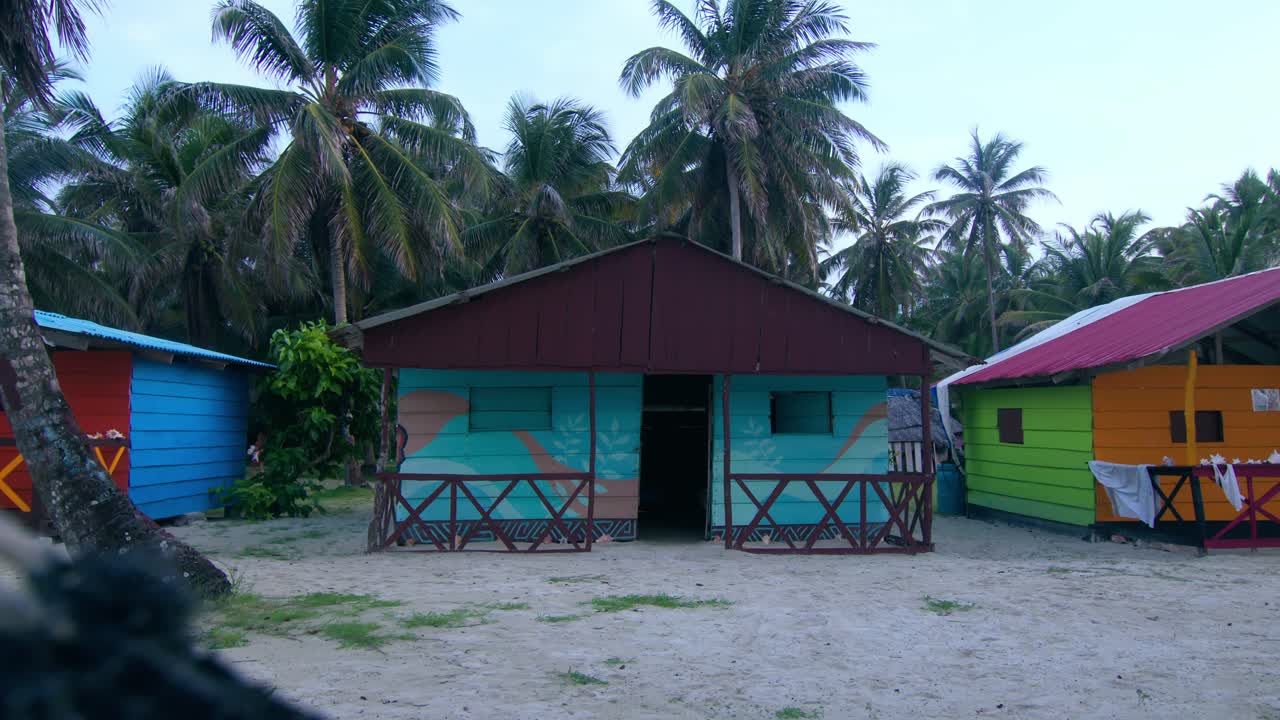 Typical colorful houses in San Blas Islands, Panama, with palm trees at blue hour