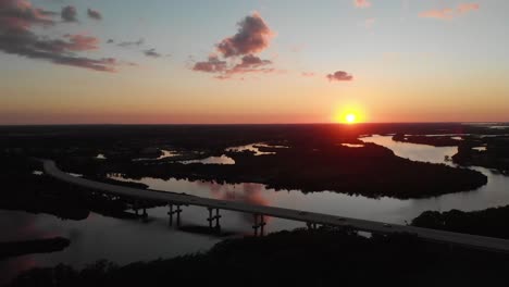 a bridge over backwaters during sunset (aerial)