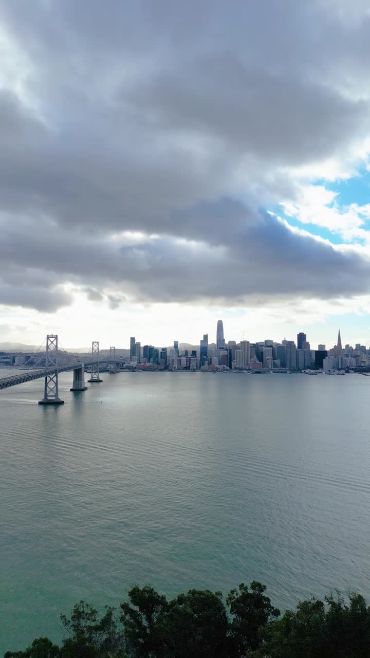 Side-tracking drone shot of the Bay Bridge from Yerba Buena Island, offering a scenic view toward San Francisco's skyline.