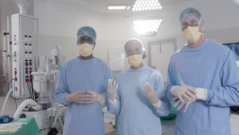 portrait of diverse surgeons with face masks in operating room in slow motion, unaltered