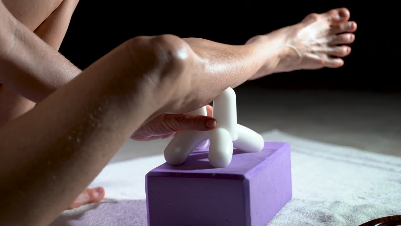 그녀의 다리 종아리에 근막 치료를 위한 마사지 도구를 사용하는 성숙한 여성의 낮은 근접 촬영 보기