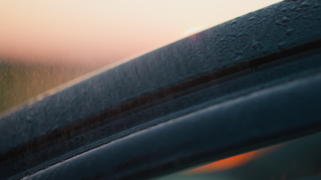 Car under rainstorm at dusk time closeup vehicle surface with clear water drops at rainstorm in